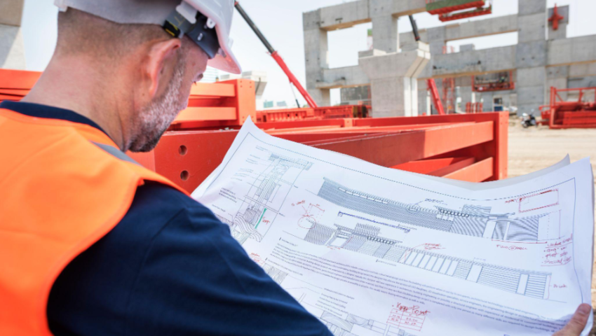 Ingegnere in cantiere analizza un progetto tecnico per la costruzione di un data center e infrastrutture digitali avanzate